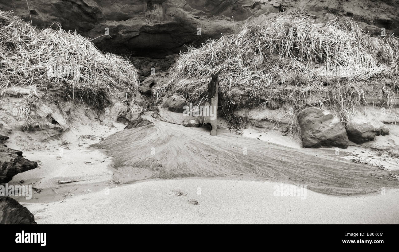 Black and white landscape photo of sand flowing from a stream mouth onto a beach on the Oregon Coast.  Lincoln City, Oregon, USA. Stock Photo