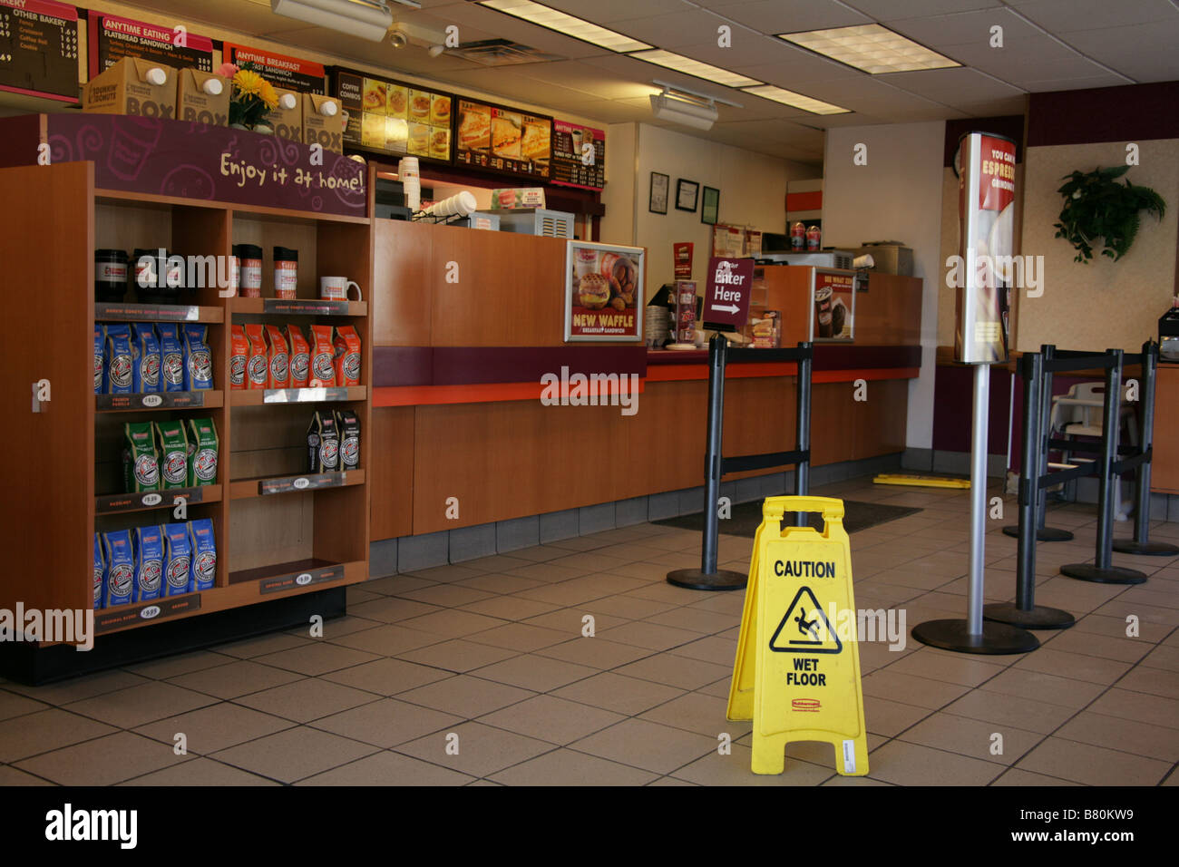 A wet floor sign in a Dunkin' Donuts coffee shop in the United States. Stock Photo