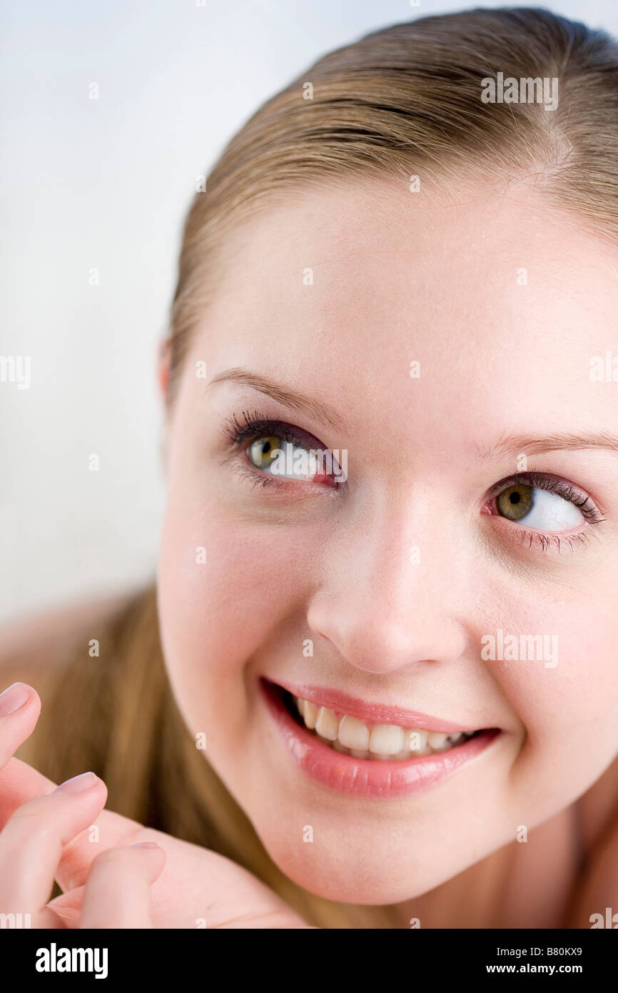 Close up to a young woman s face looking aside smiling Stock Photo