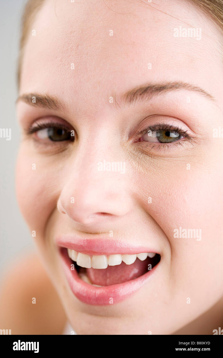 Close up to a young woman s face smiling side view Stock Photo