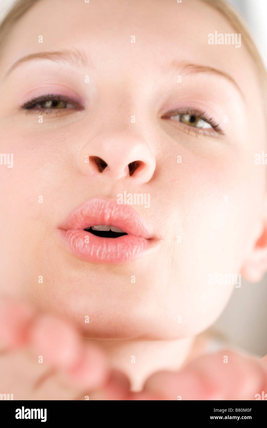 Young woman blowing toward the camera close up Stock Photo