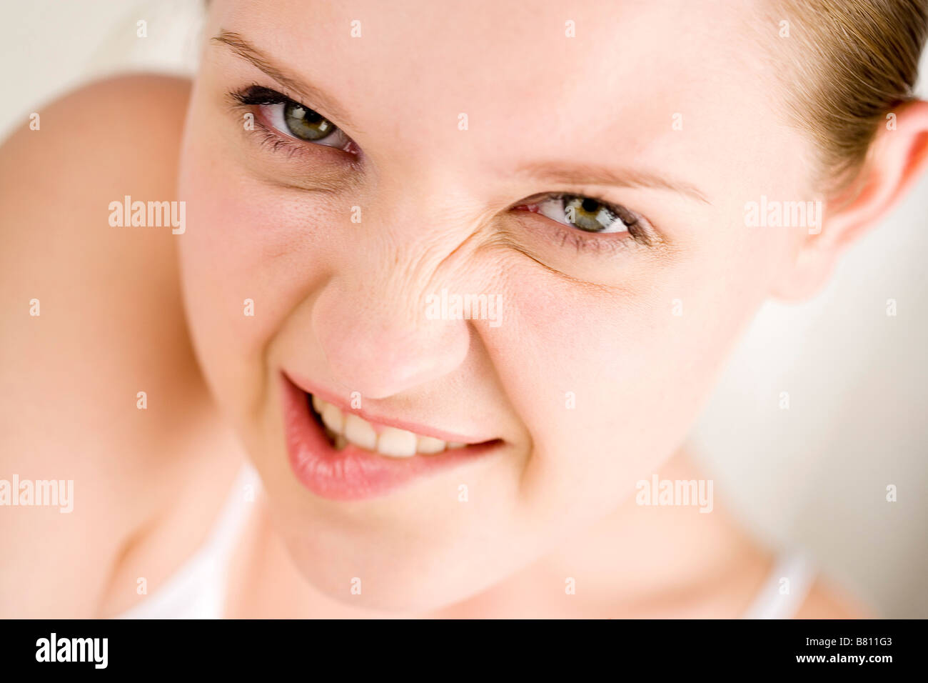 Young woman laughing and squinching up nose close up Stock Photo