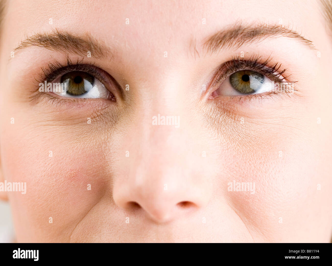 Close up to a young woman s face eyes looking up Stock Photo