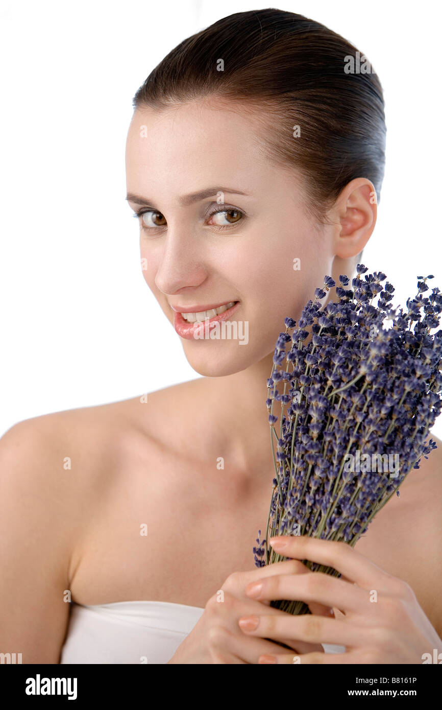 Young woman holding a bunch of lavender head and shoulder looking at