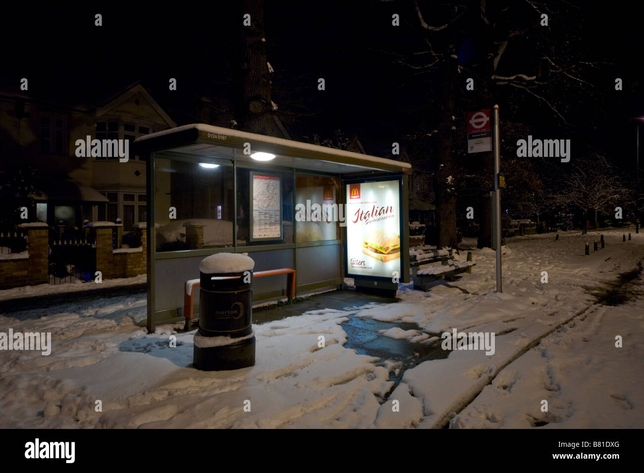 Suburban bus Stop in London at night in the snow Stock Photo