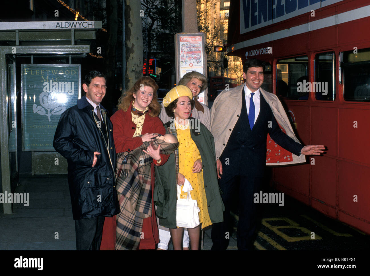 A group of the UK's Royal family impersonators wait at a bus stop to catch a red double-decker bus. London. England, UK,  Circa 1989 Stock Photo
