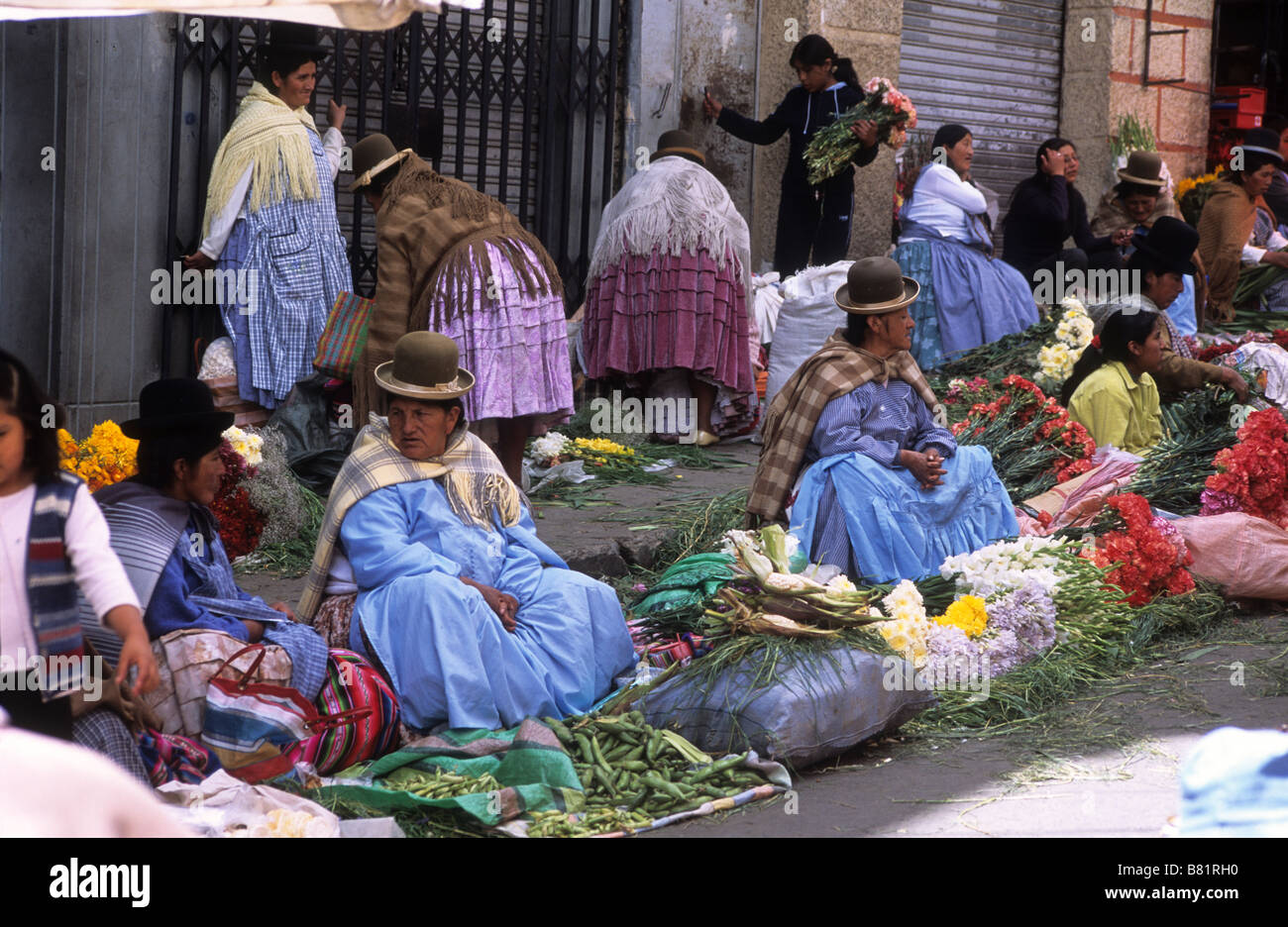 Aymara ladies (cholitas) in traditional dress selling flowers in Mercado Rodriguez, a typical street market near the city cente, La Paz, Bolivia Stock Photo