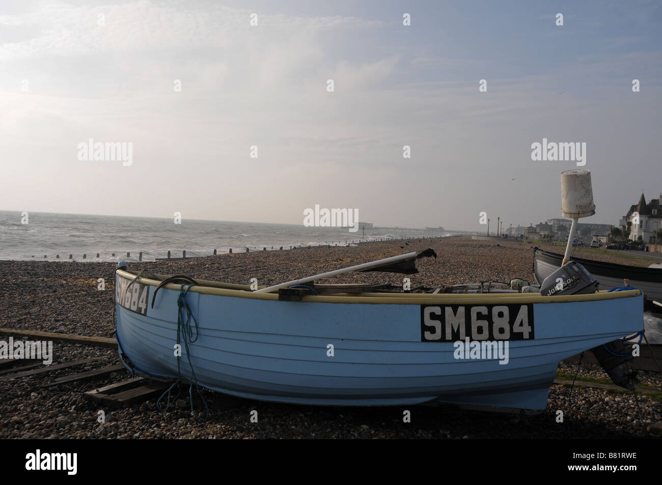 A small light blue fishing boat on the beach at Worthing on the English ...