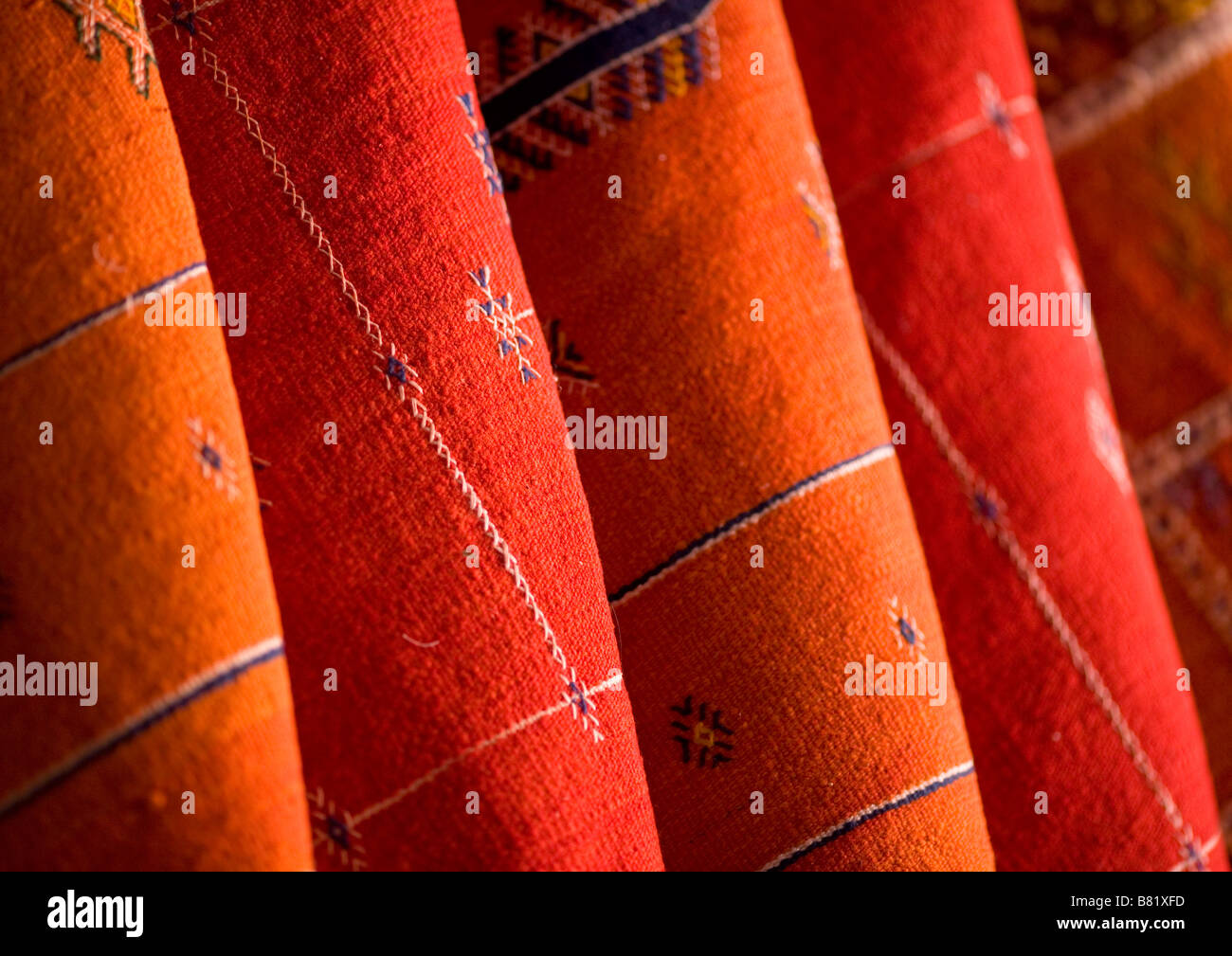 Red and orange Morrocan rugs hung for sale in the souks of Marrakech, Morocco Stock Photo