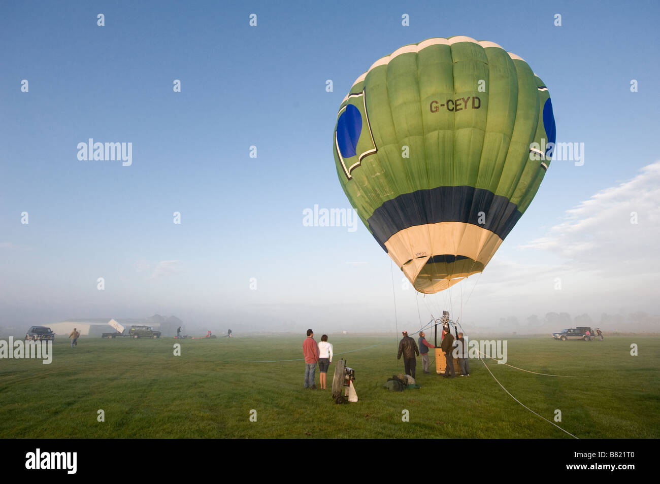Using burners to inflate a hot air balloon on a cold foggy morning in