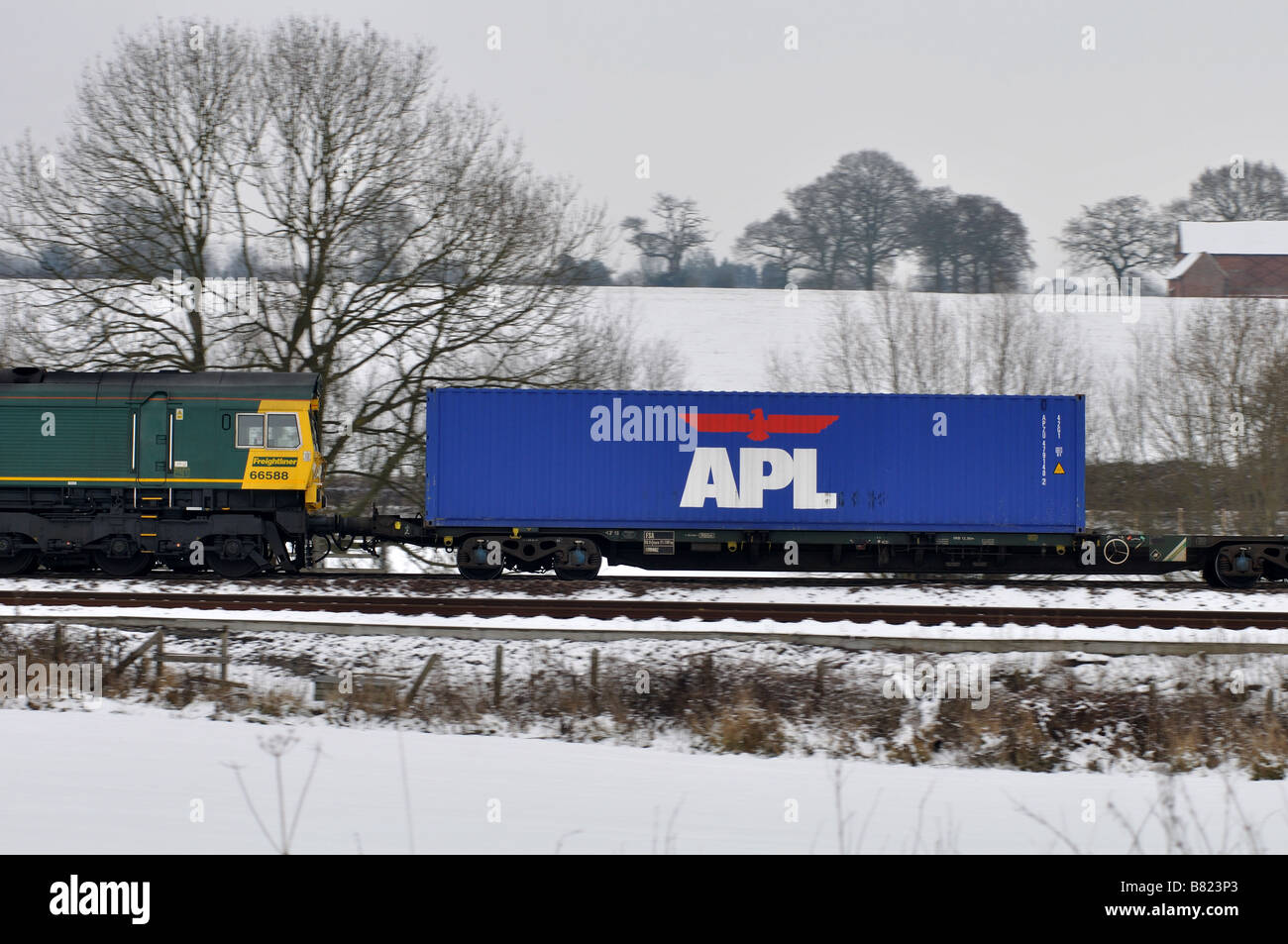 APL shipping container on freightliner train in snow, UK Stock Photo