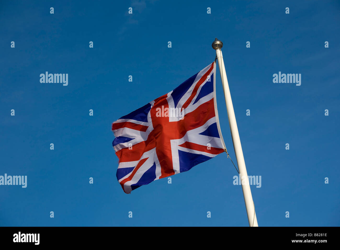 Union Jack flag flying on flagpole against blue sky Stock Photo - Alamy