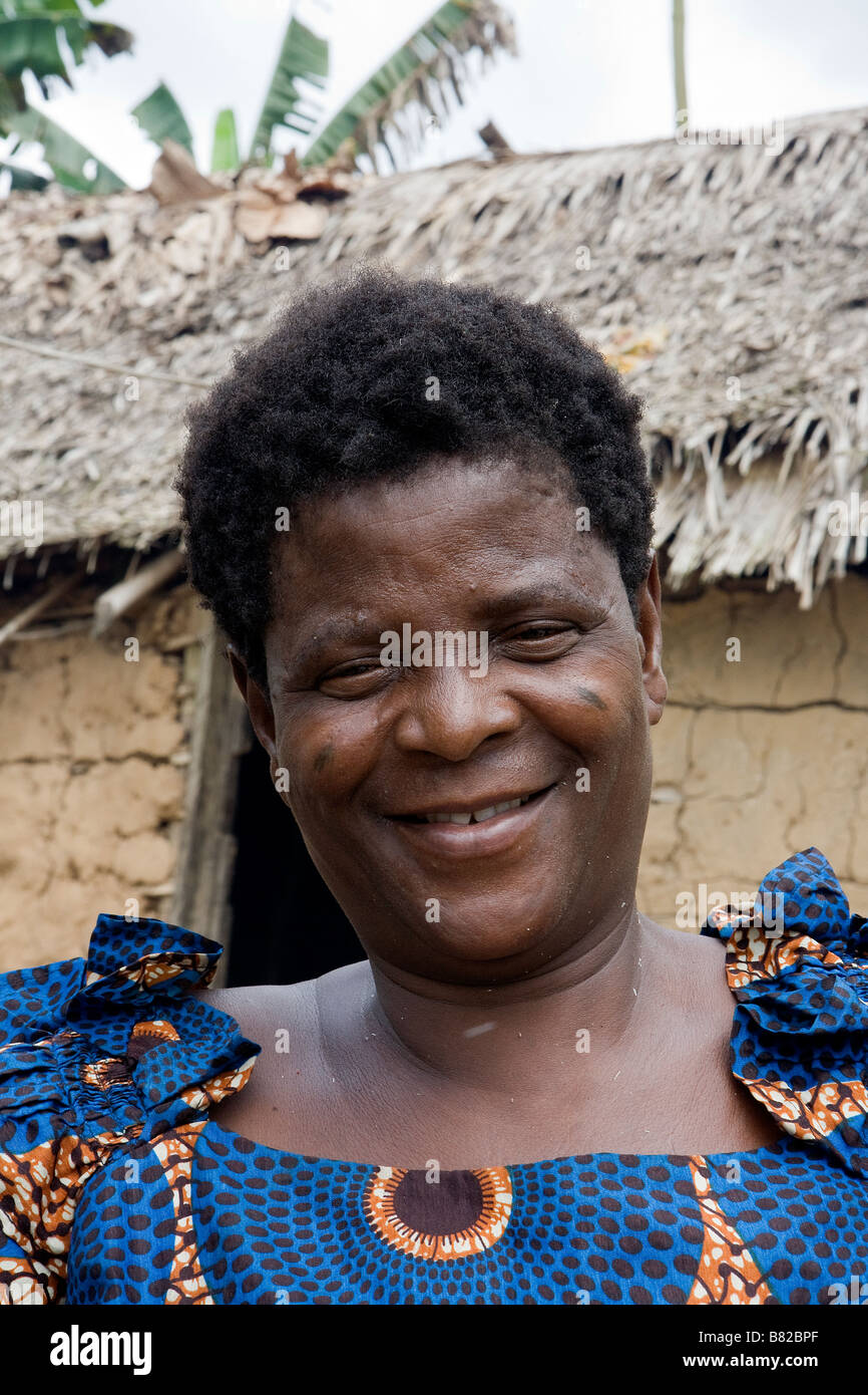 Nigerian woman from a remote jungle village in Epe happily poses for a head and shoulders photograph before her mud hut Stock Photo