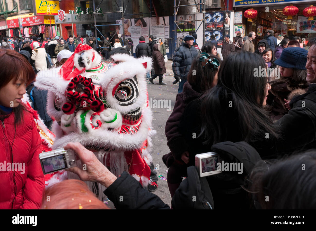 New York City, NY - Tourists pose for pictures with Lion Dancer on Mott Street Stock Photo