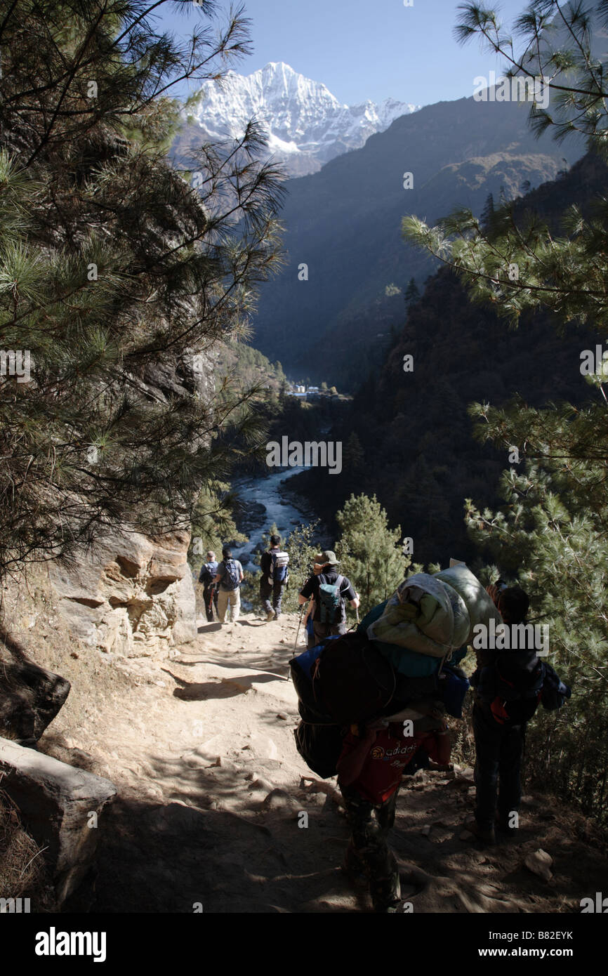 Trekkers and porters passing each other on trail in Khumbu region Nepal Stock Photo