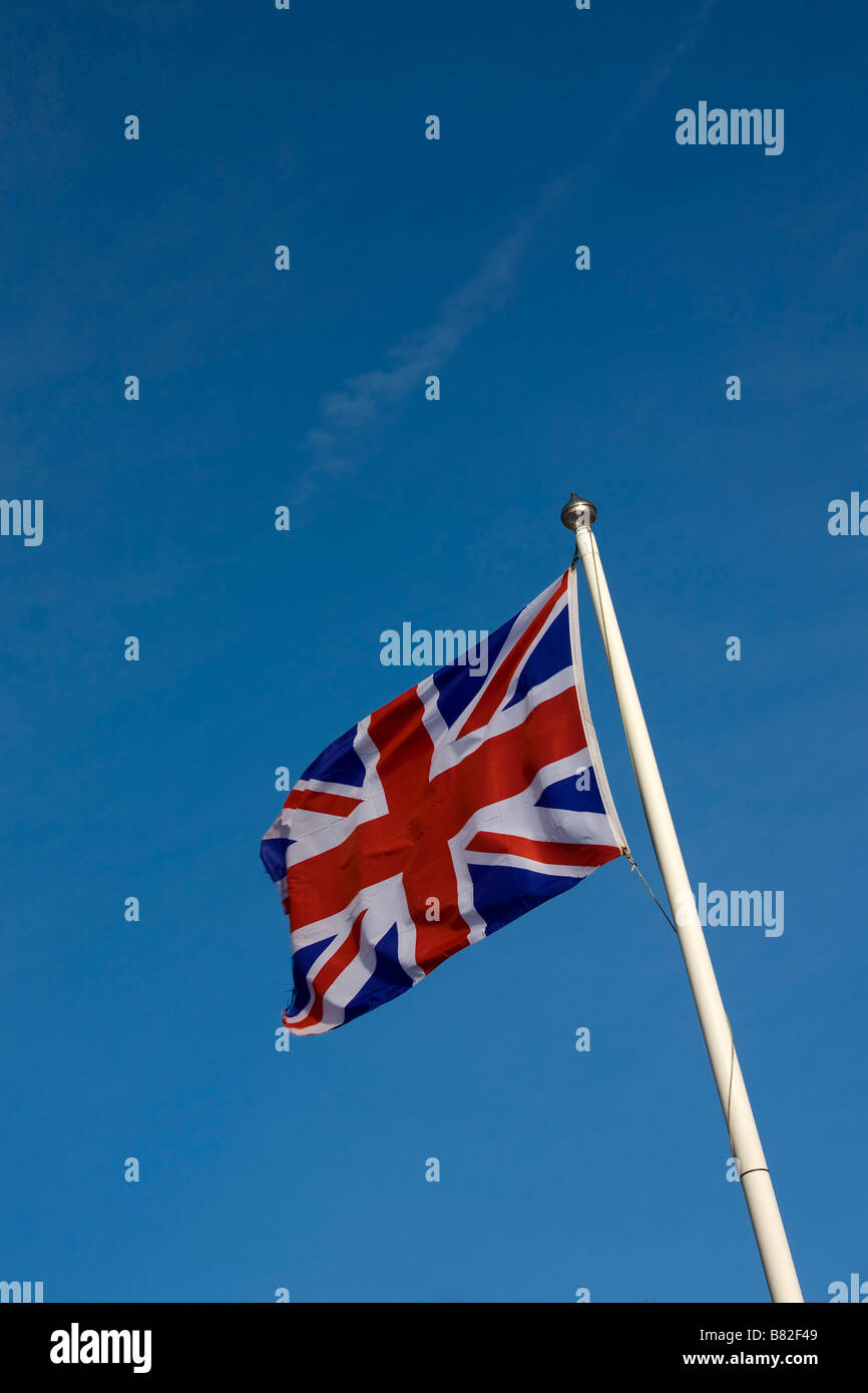 Union Jack flag flying on flagpole against blue sky Stock Photo - Alamy