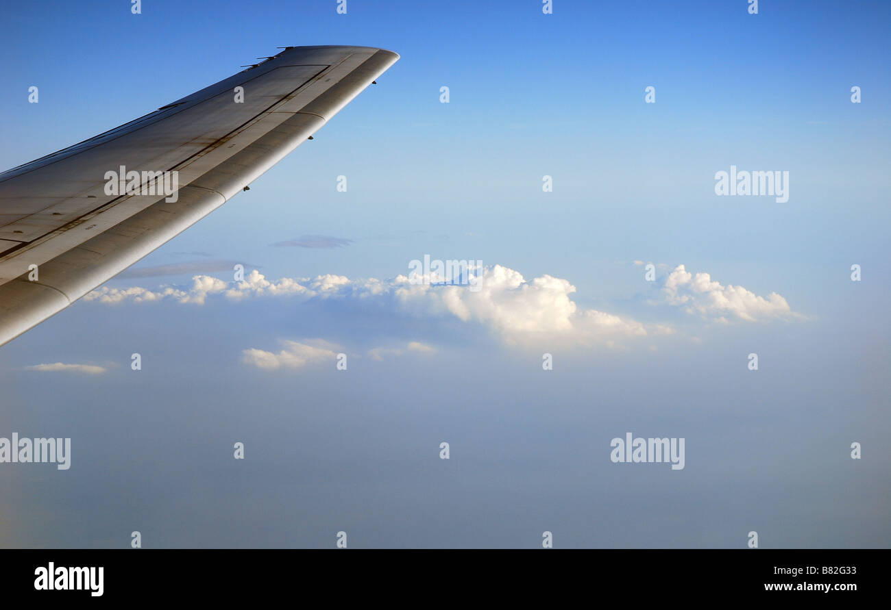 Aircraft wing and clouds seen from aircraft window Stock Photo