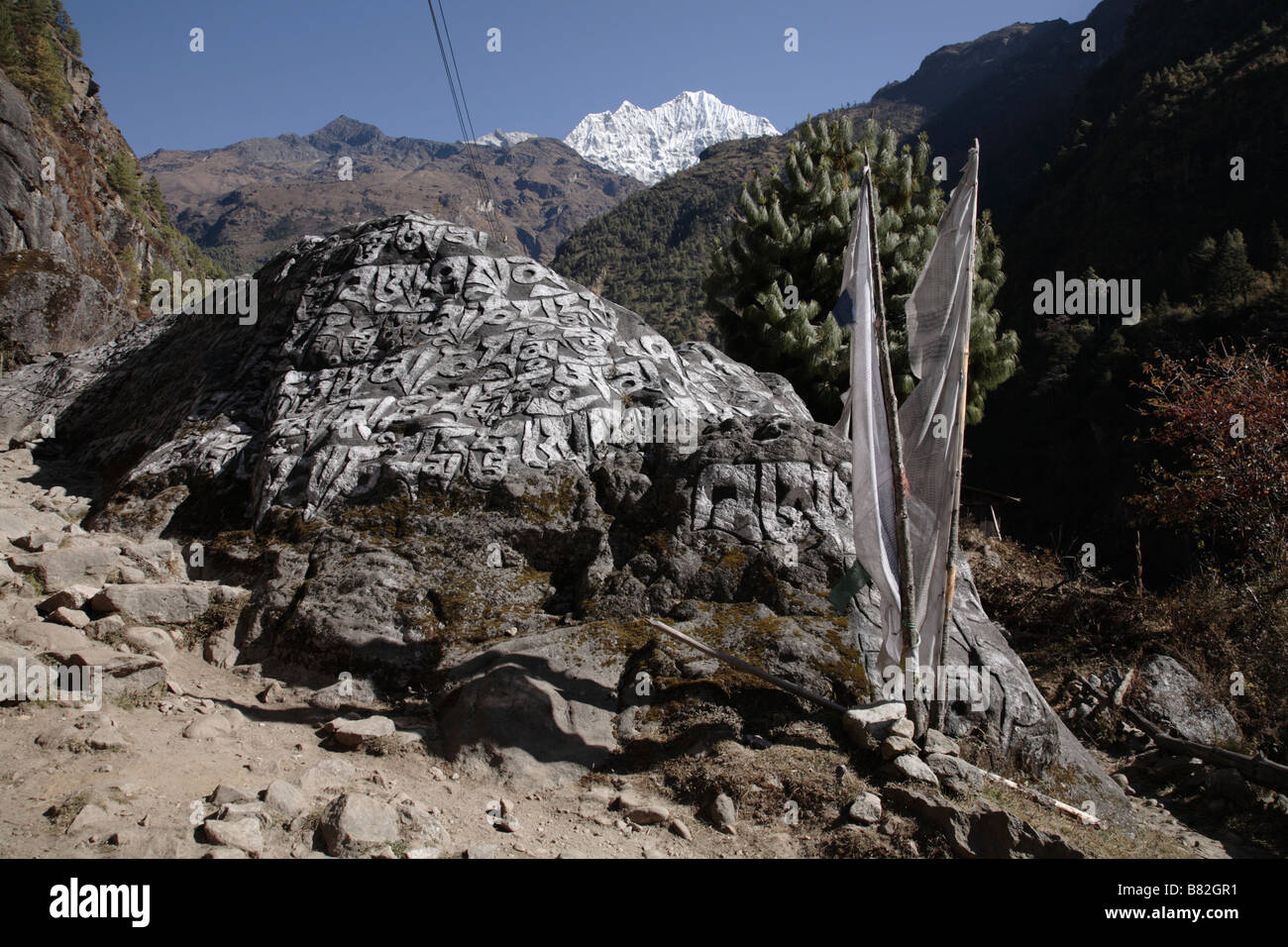 Buddhist prayer stones and prayer flags on trail in Khumbu valley Nepal Stock Photo