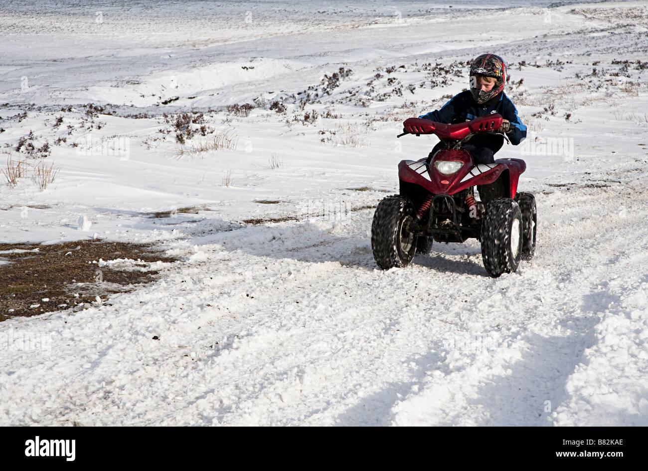 Boy on motorised buggy playing in snow Wales UK Stock Photo