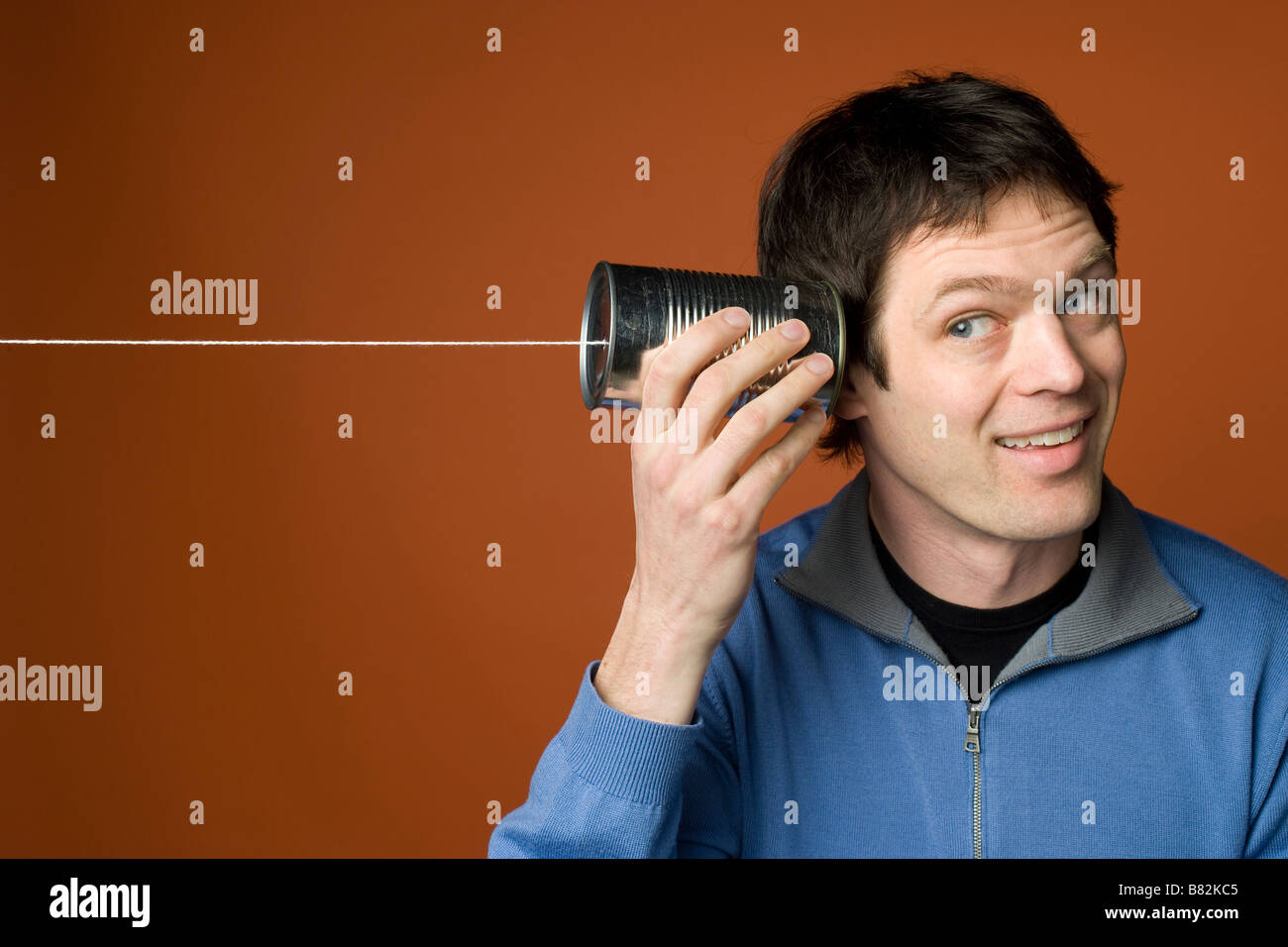 Man uses tin can and string to listen to a message Stock Photo Alamy