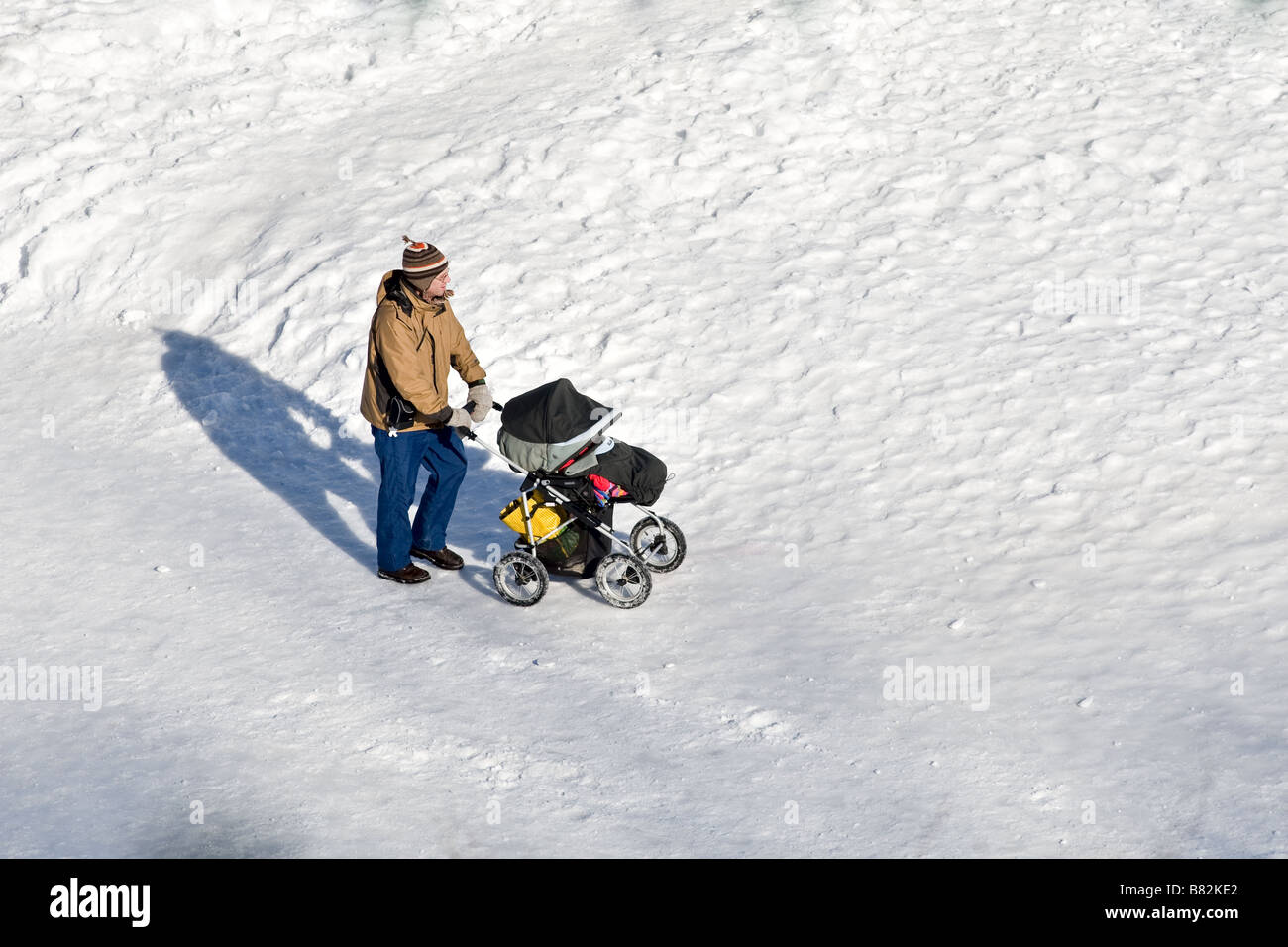 A man walks with a stroller on the snowy Terrasse Dufferin in Quebec city Stock Photo