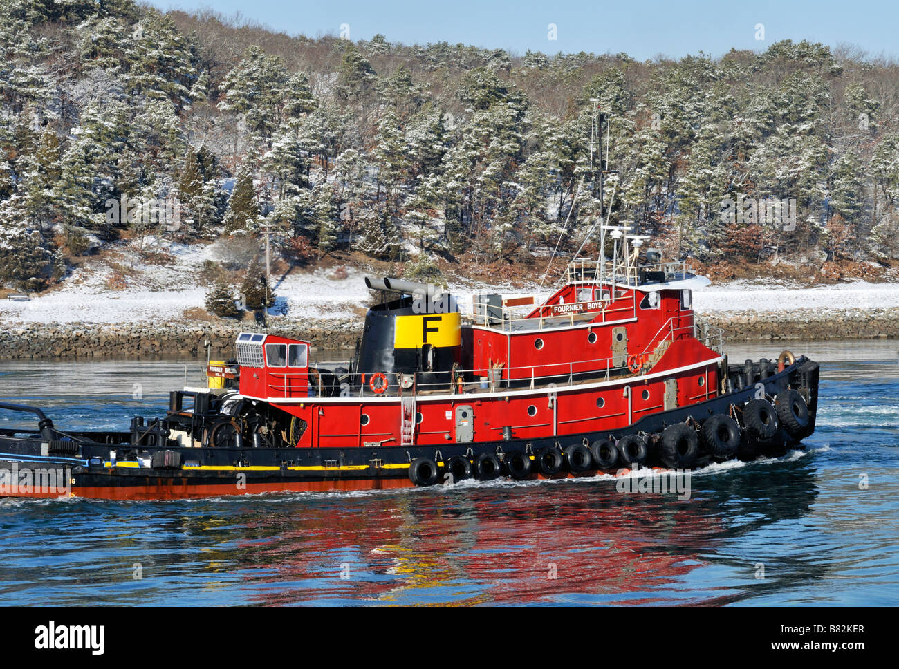 Classic style tugboat in picturesque New England winter scene moving through Cape Cod Canal Stock Photo