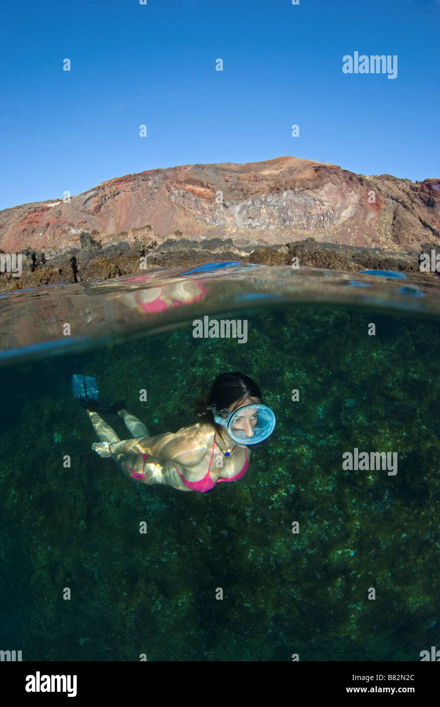 El Hierro Canary Islands snorkeler split view volcanic island, female diver, oval mask, bikini, fotosub, freediving Stock Photo