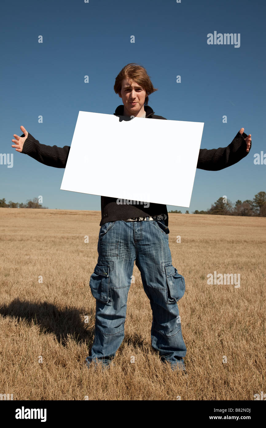 A 21 year old guy hold up a blank sign that you can use to place your message on  Stock Photo