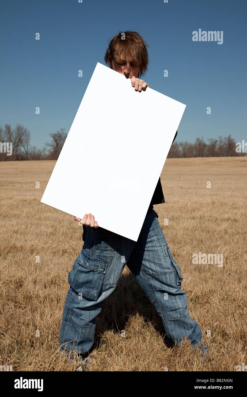 A 21 year old guy hold up a blank sign that you can use to place your message on  Stock Photo