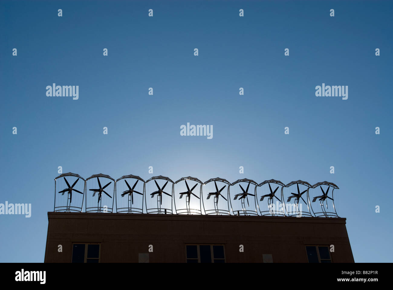 Wind turbines are seen on the roof of an apartment building under ...
