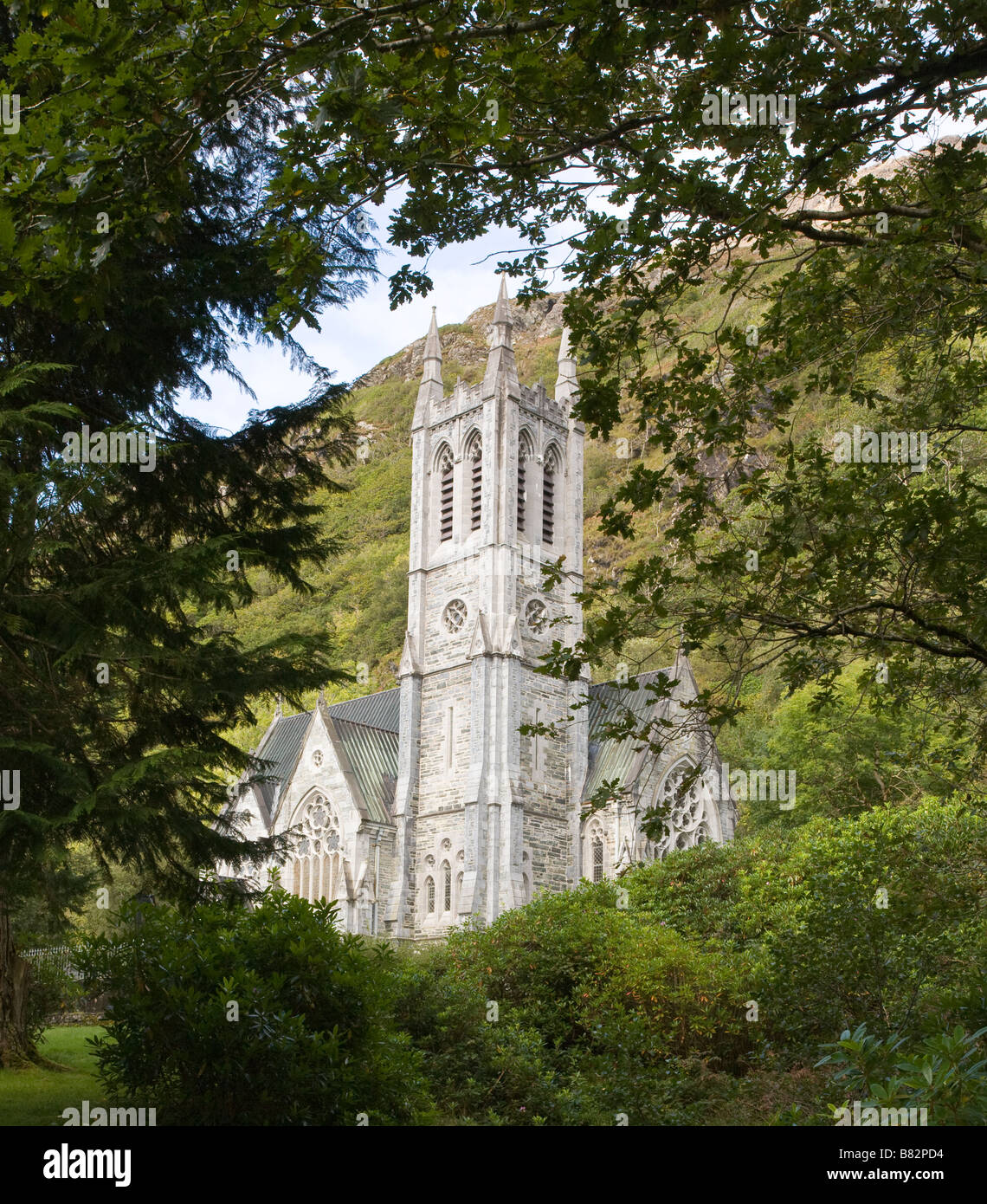 Gothic Chapel at Kylemore. The spire of the chapel at Kylemore surrounded by the trees of the grounds Stock Photo
