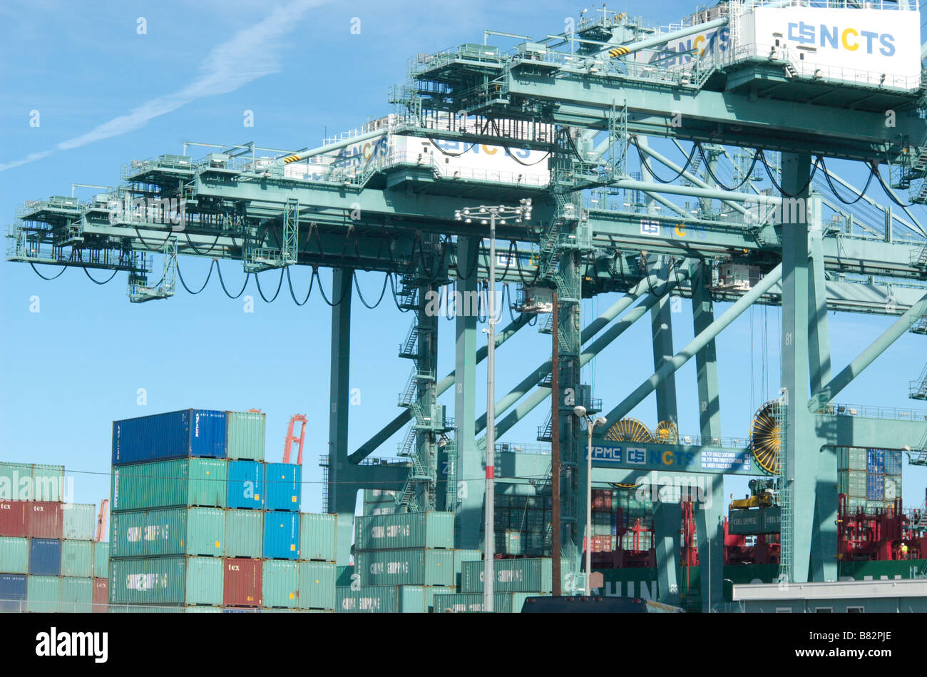 A group of shipping container movers that are loading and unloading a group of shipping