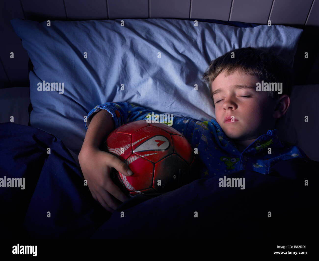 boy sleeping and dreaming of football grasping a ball Stock Photo Alamy