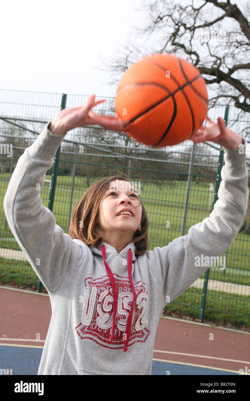 Teenage girl practicing netball in a park Stock Photo