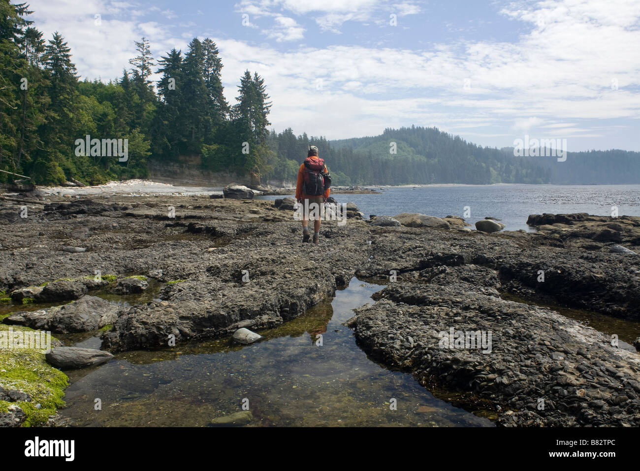 BRITISH COLUMBIA - Hiker on the Juan de Fuca Marine Trail at Sombrio Beach along the edge of the Strait of Juan de Fuca. Stock Photo