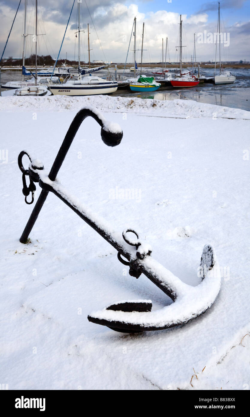 Ships anchor in snow with pontoon full of snow covered boats Stock Photo