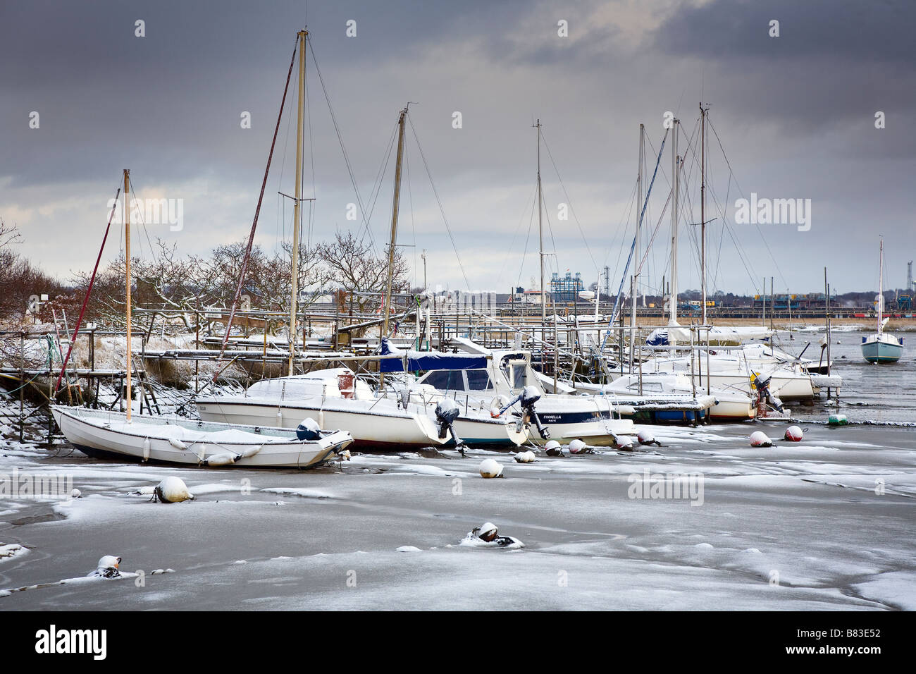 Snow covered boats aground on frozen mud Stock Photo