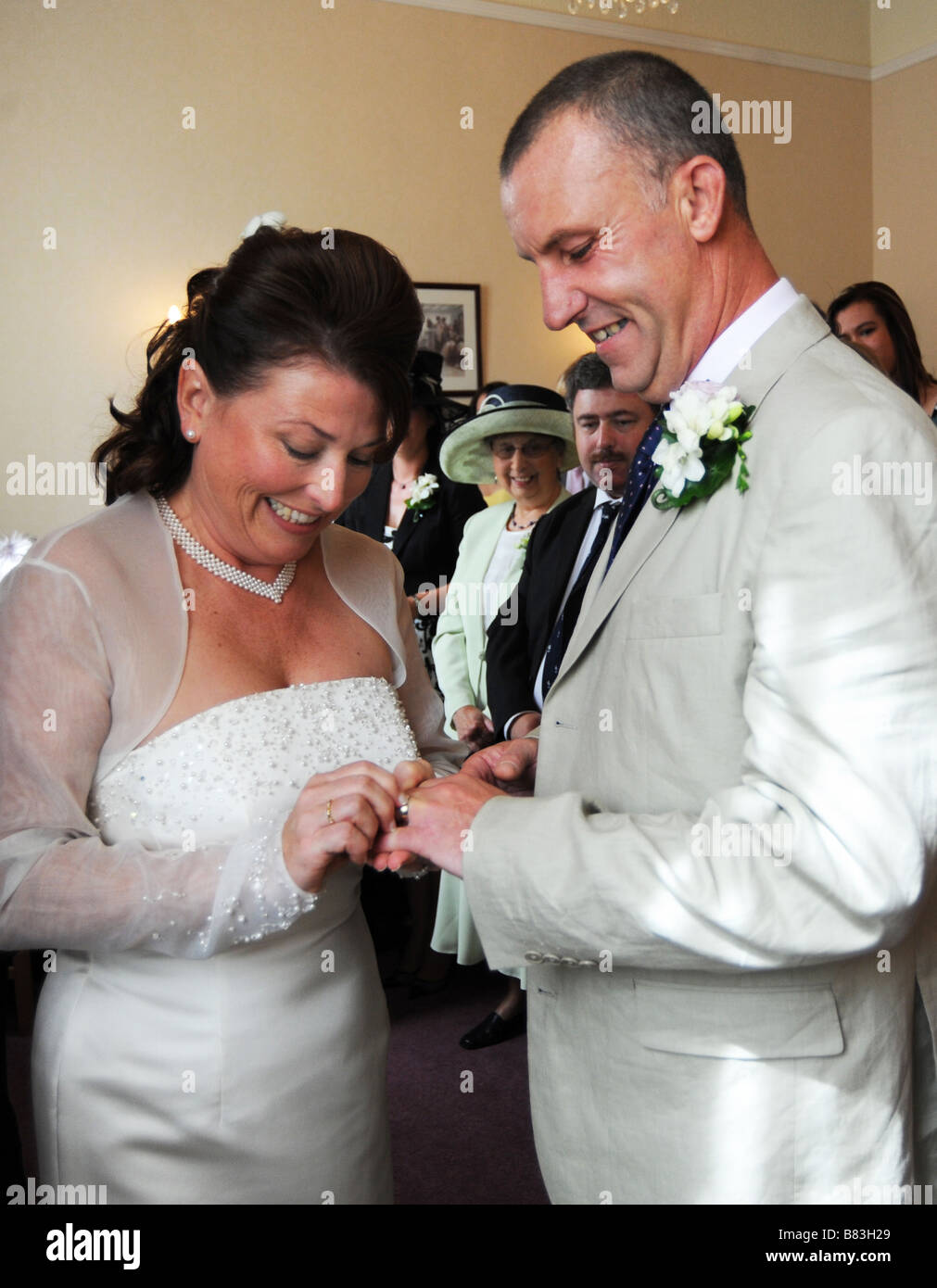 A couple put on wedding rings during their wedding ceremony, North