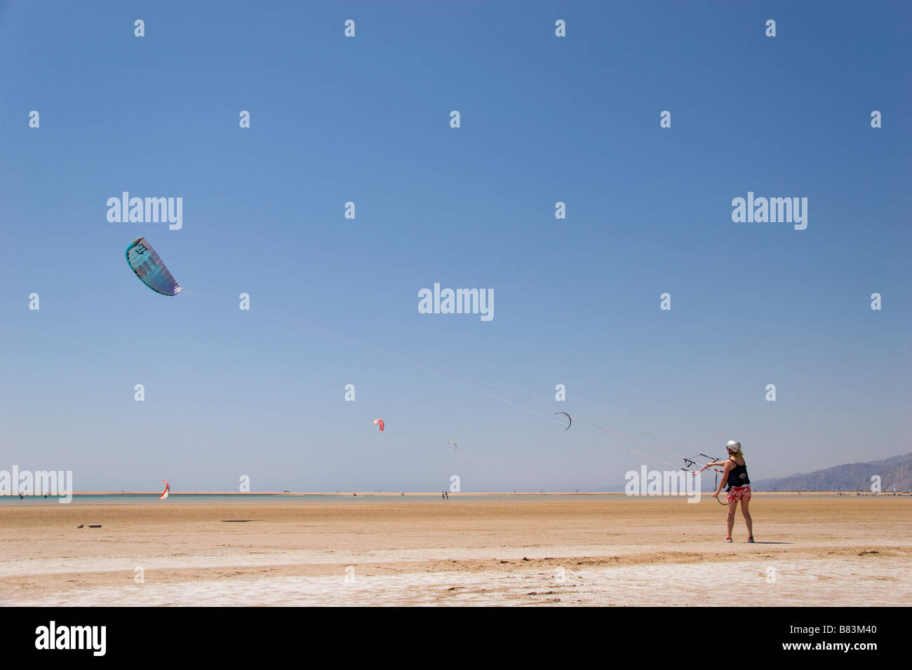 A kitesurfer practices flying a kite when the tide is out in Laguna Bay (Qura Bay) in the Sinai resort of Dahab in Egypt Stock Photo