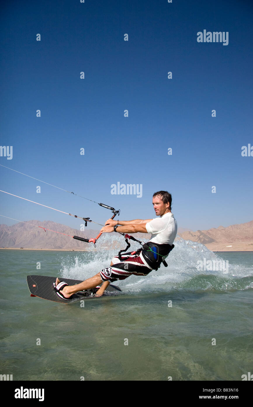 A kitesurfer crosses the turquoise flat water lagoon (Qura Bay) within the sand spit in the Sinai resort of Dahab in Egypt Stock Photo