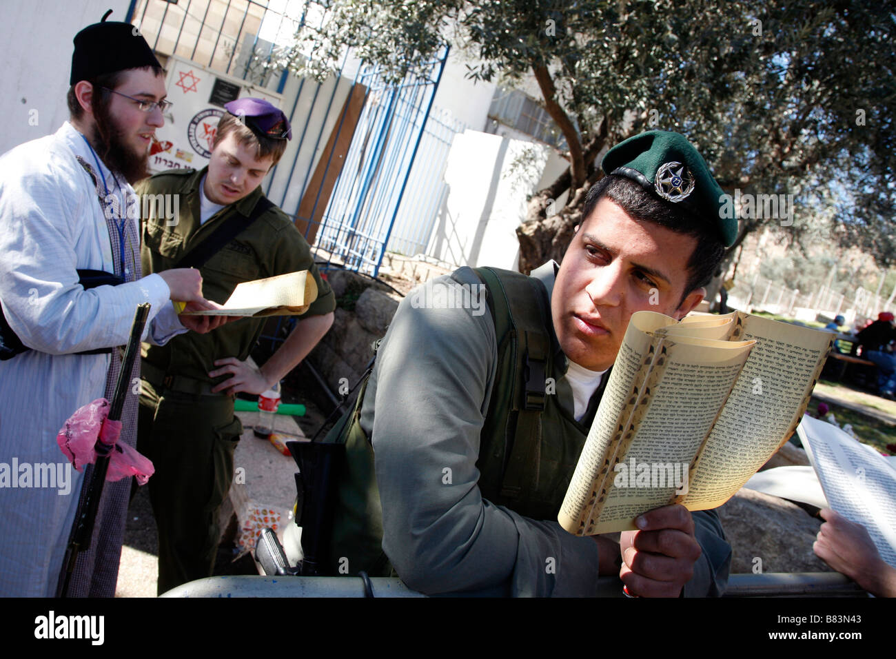 Israeli policeman reading a Jewish religious text during Purim celebrations in the West Bank