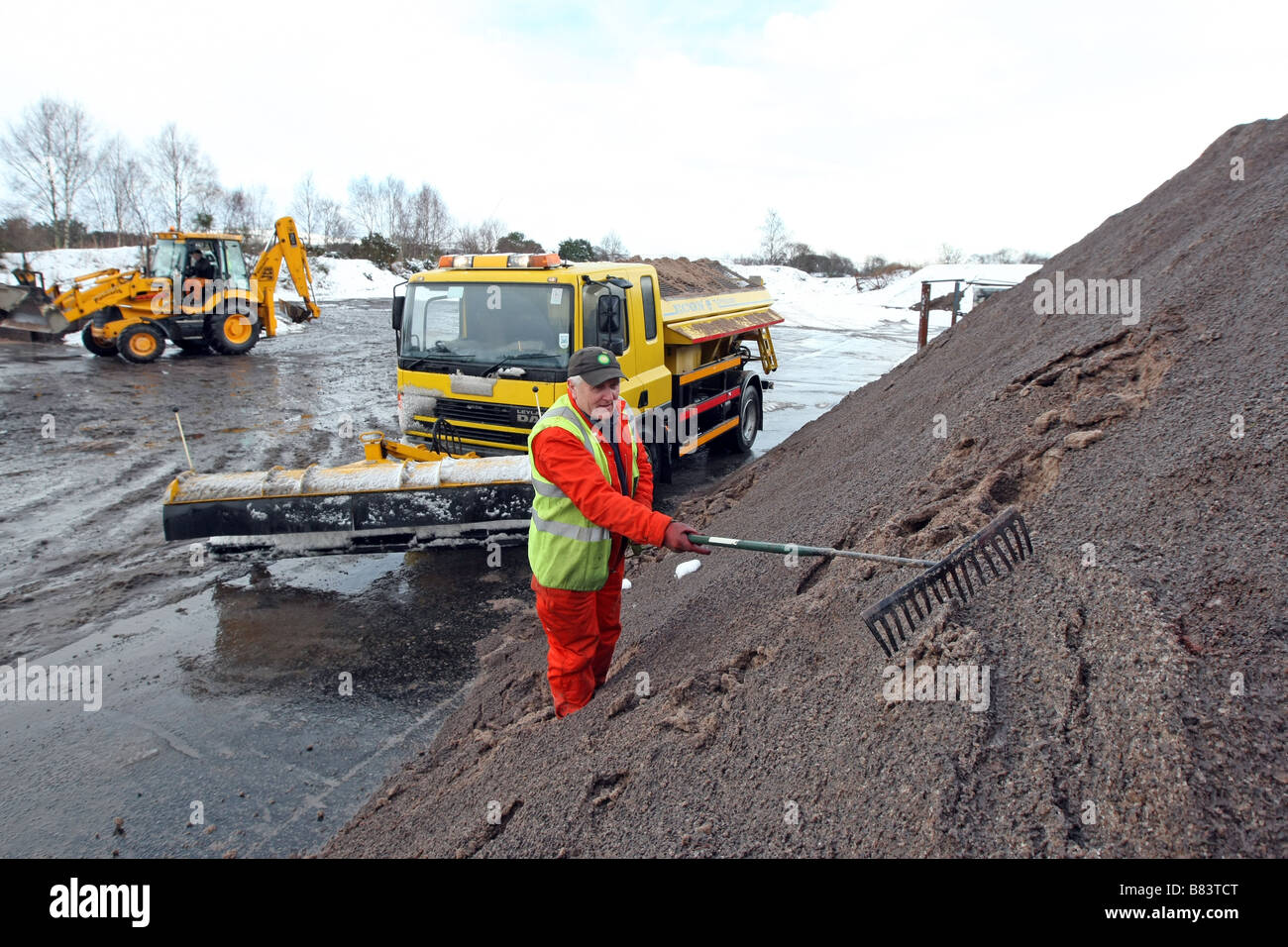 Gritters and snow ploughs being loaded with road grit at council roads