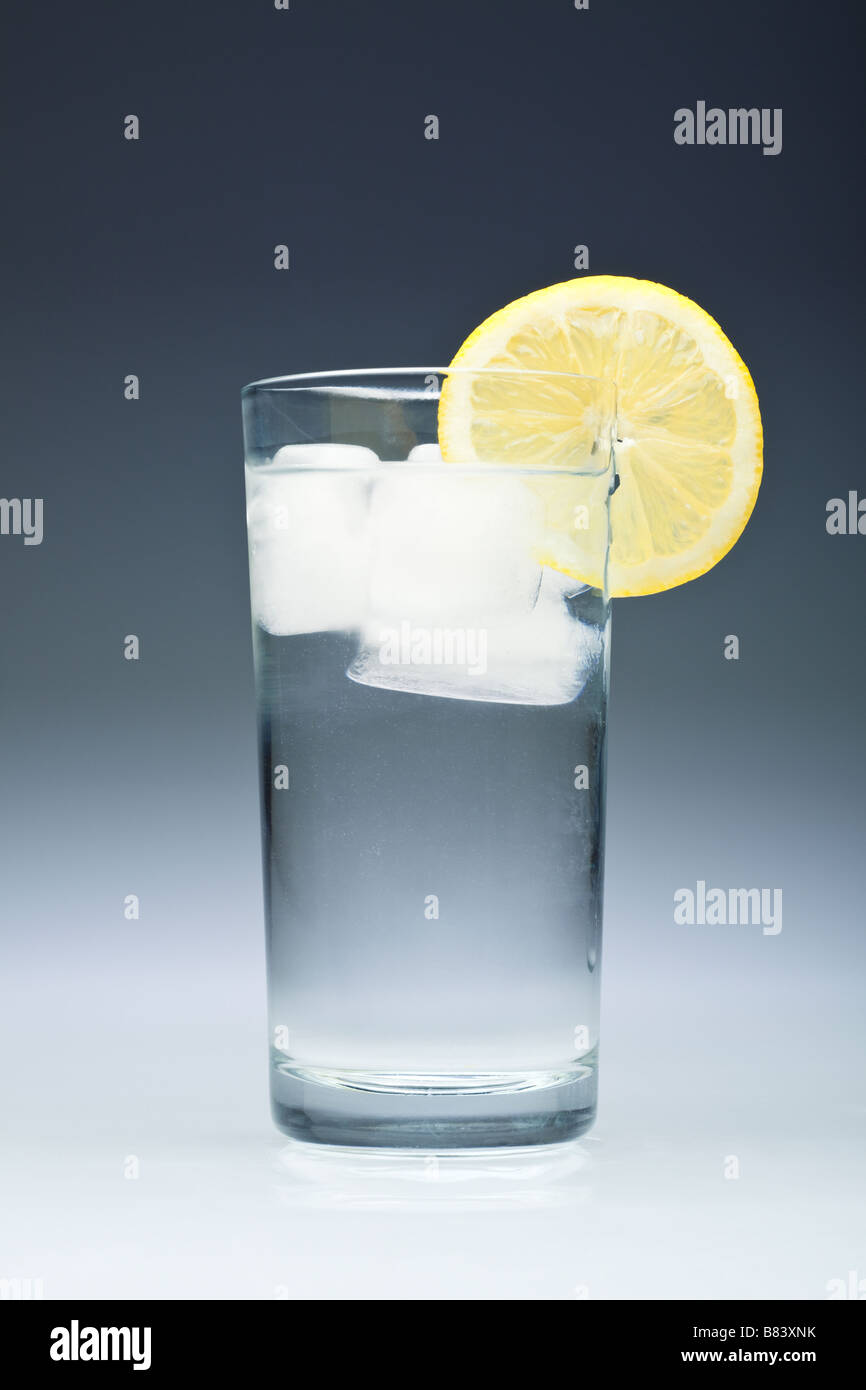 Tall glass of water with ice cubes and a slice of lemon close up studio Stock Photo