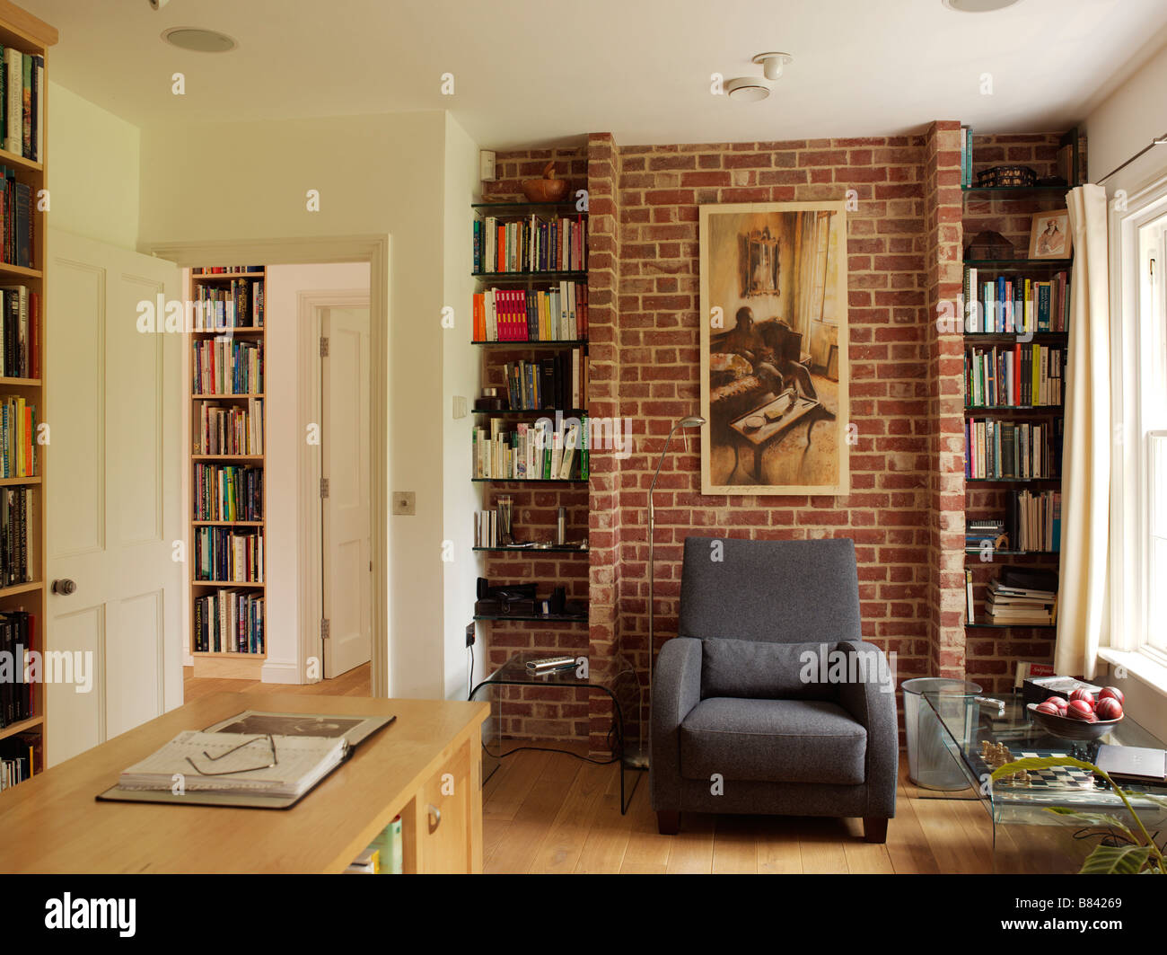 Living Room With Neutral Decor And Large Wall Bookcase Stock Photo