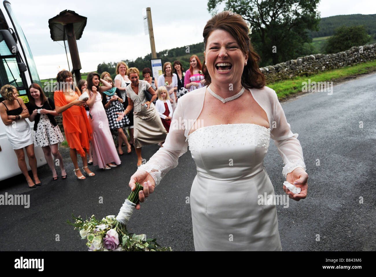 A bride throws her bouquet to wedding guests North Yorkshire Stock Photo