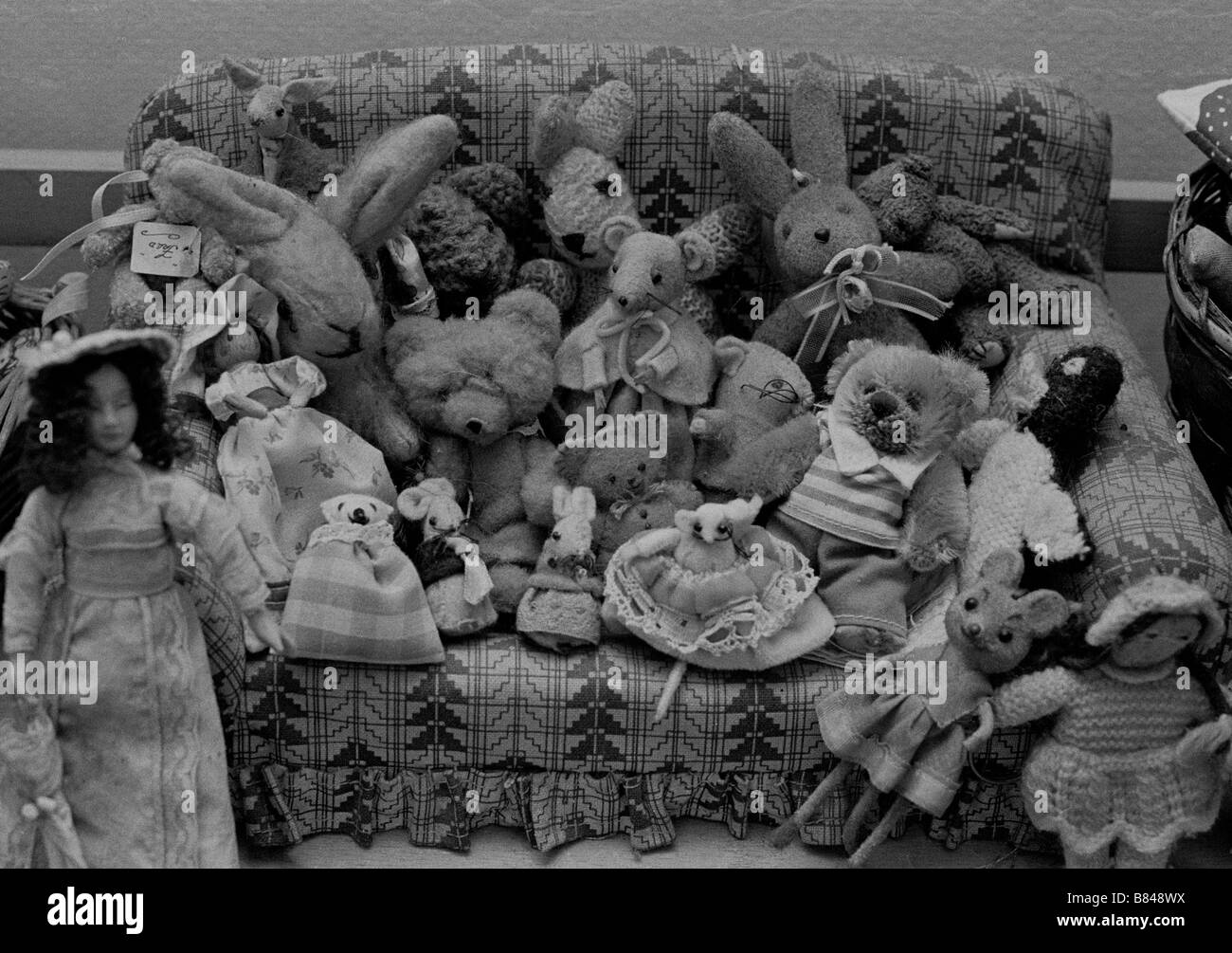 Toy bears, dolls and mice on a miniature sofa Stock Photo