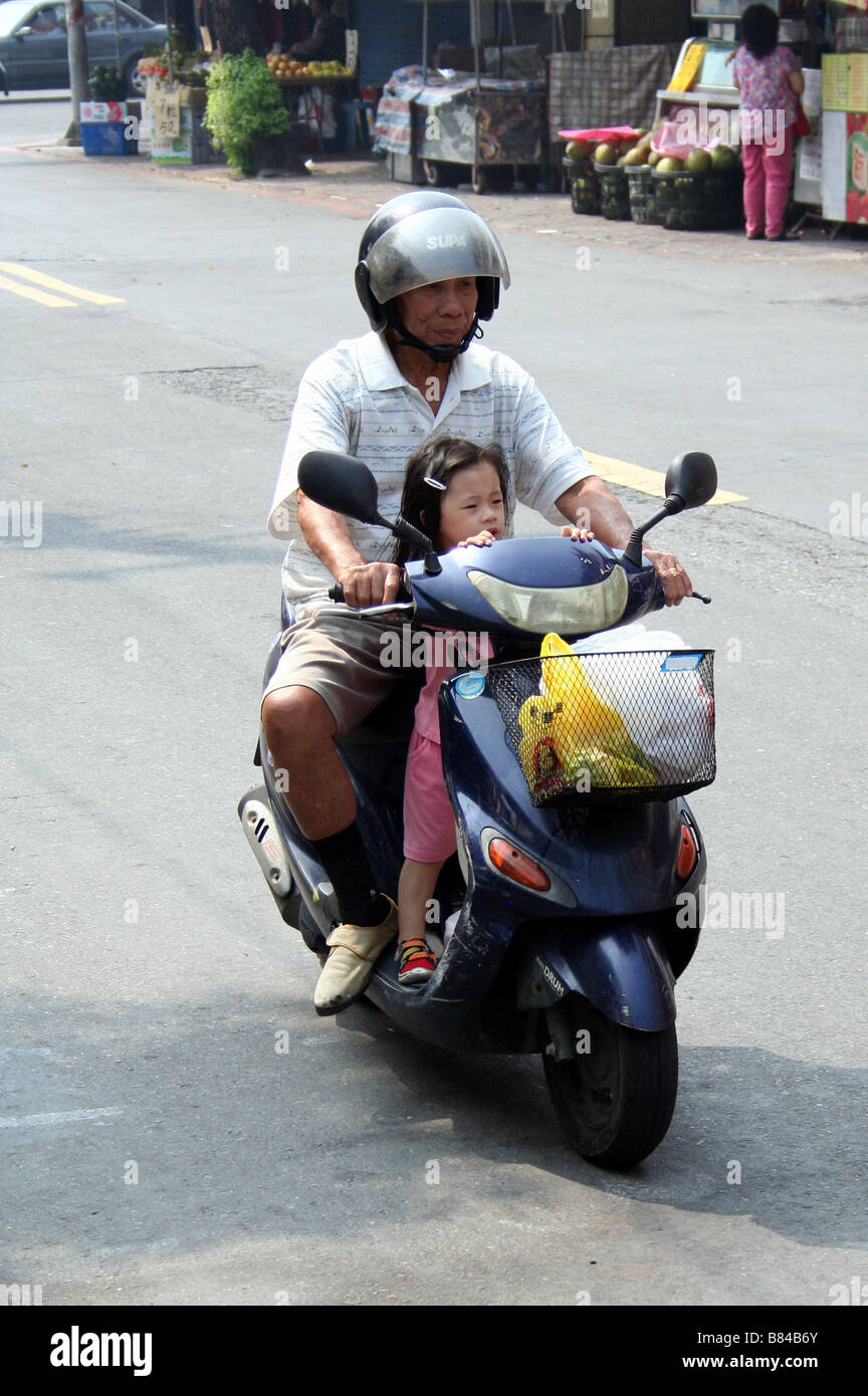 Man and Boy on a Moped in Taiwan Stock Photo