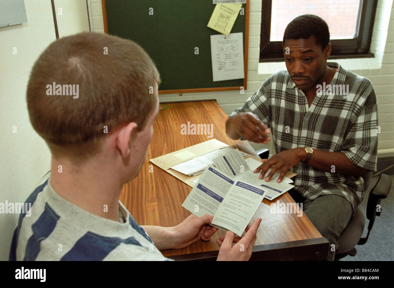 Black Probation Officer talking to a white young adult Stock Photo
