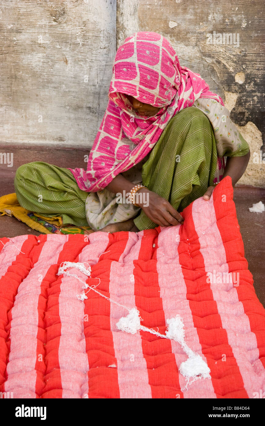 Indian woman sewing needle and thread through cloth Bikaner Rajasthan