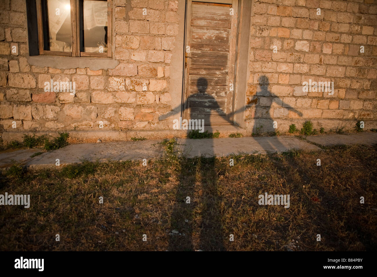 two shadows playing on a poor house Stock Photo